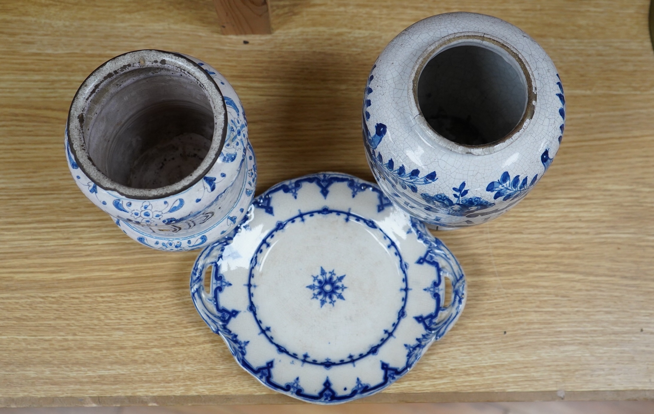 A 17th /18th century blue and white Delft apothecary jar, together with an Italian blue and white pottery drug jar and a blue and white ‘Saxon Star’ two handled dish, tallest 19cm. Condition - poor